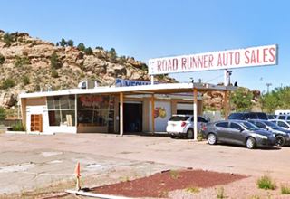glass plated corner office, flat canopy over 2 gas pump islands, 2 service bays right