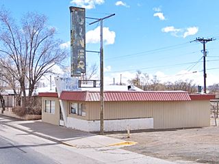 Hollywood diner, US66 diner color. single story building, crest by door, faded vertical neon sign