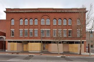 red brick building, many windows, facing Route 66, three floors