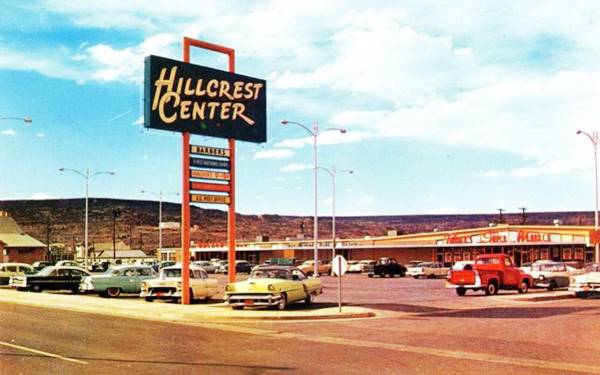 late 1950s color postcard, neon sign reads HILLCREST CENTER, 1950s cars in parking lot, mall beyond