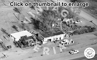 aerial photo black and white, gas station, pumps, vehicles, US 66 lower part of image, tires on the left