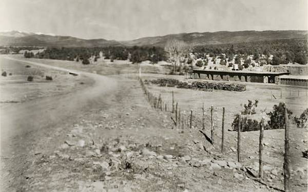 1920s Koslowski ranch view Black and white, 1920s, US 66 dirt surfaced, to the left, bridge ahead, on the right an adobe ranch, trees. Hills with forests
