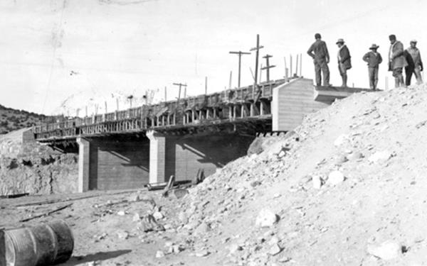 workers building an overpass over rairoad tracks, black and white 1932 picture