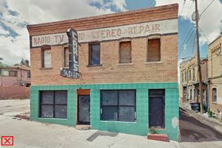 brick 2 story commercial style building from the 1900s former hotel, neon sign and painted parapet