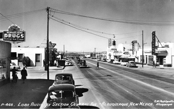 1940s black and white photo of Central Ave. Lobo Theater, cars, people and a drugstore, restaurant and shops