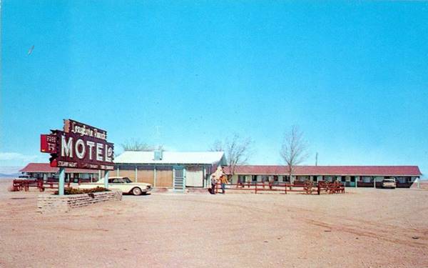 Longhorn Ranch Motel c.1960, US66 Moriarty motel units parallel to highway behind an office, gravel driveway, motel red and white sign. All seen from US66 color 1960s postcard