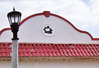 detail of the magnolia flower on the canopy of the Magnolia Station 4th St ABQ white and red curvilinear canopy with a magnolia flower inset in the facade