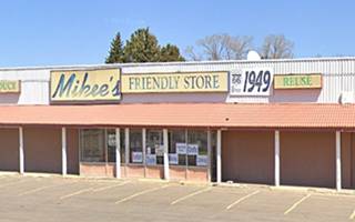 sheet metal faced store, signs on parapet, awning