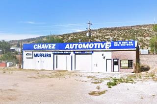 color view single story warehouse, brick office to the left, entry bays to the right, gravel parking area in front, hills beyond. Seen from Route 66