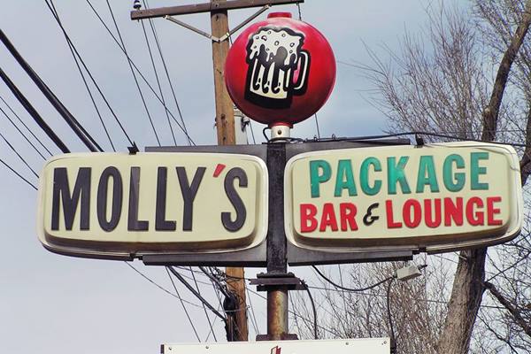 a neon sign reading MOLLY - package bar & lounge, topped with a white beer mug in a red circle