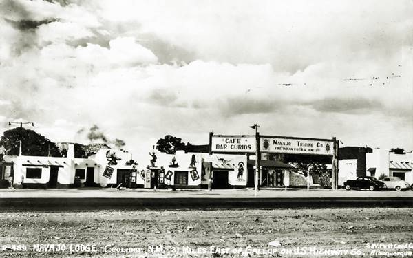 Navajo Lodge postcard, Coolidge NM Route 66 black and white postcard, lodge, trading post with US 66 running in front of it. Pueblo sytle white buildings, single story with vigas, 1940s