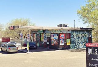 flat canopy, box-shaped gas station, glazed corner office, empty pump islands, grafitti covered former Conoco Station