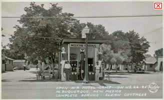 1930s postcard Open Air Camp 1930s black and white postcard of a Conoco with two men each by a gas pump, trees and cabins on both sides