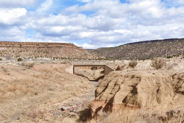 Original US66 bridge in Paraje concrete bridge c.1920s hills and cliffs behind, dry creek, arid country