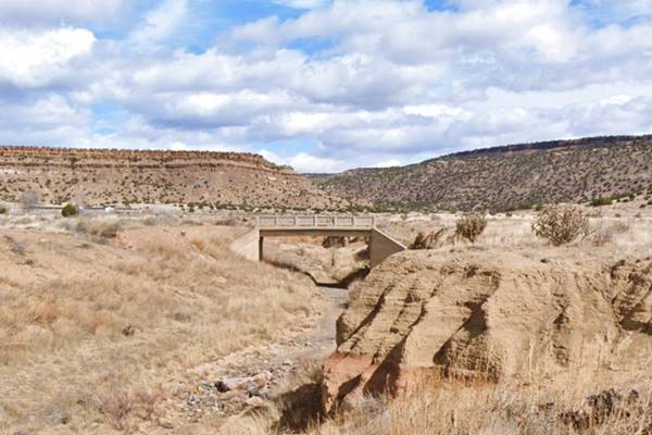 concrete bridge c.1920s hills and cliffs behind, dry creek, arid country