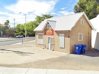 cottage shaped building with gable roof on a corner former gas station