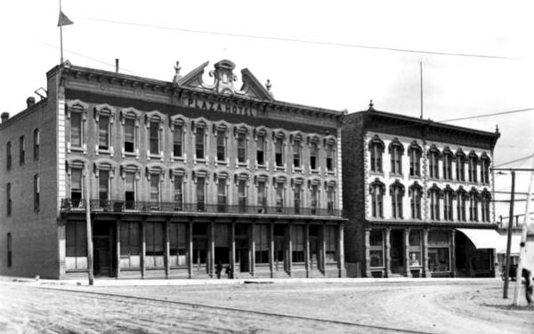 black and white, large brick building with 3 stories PLAZA HOTEL written on Parapet (taken in 1908)