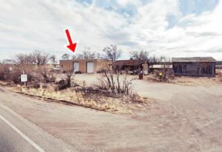 Prewitt Trading post nowadays buildings along the side of Hwy 66, shrubs, arrow marks site of old trading post