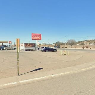color view corner paved, with some cars on it, by Route 66, looking North, highway, hill beyond