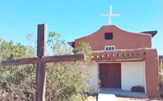 Saint Michael - San Miguel church La Bajada NM color, 2020s brown adobe church and cross on roof, cross in front of it