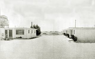 Sands motel in the 1950s Moriarty US66 black and white picture 1950s motel, office and neon sign left, units right