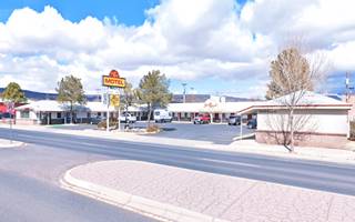 Southwest Motel in Grants NM US66 motel, yellow and red neon sign, U-shaped layout, gable roof. US66 runs in front of it