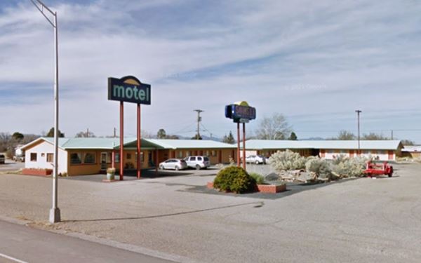 gable roof motel, two neon signs and cars parked seen from US66