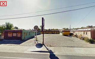 color street view from 2011 of an L-shaped vacant motel flat roof, single story