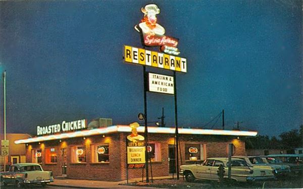 color photo at night with lit up neon light and restaurant from the 1950s