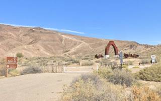 El Cerro Tomé Hill in Los Lunas steel sculpture by road and hill beyond, arid setting