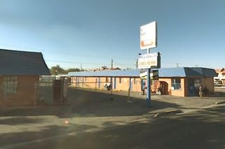 units of a motel, painted blue, neon sign and Route 66 to the right