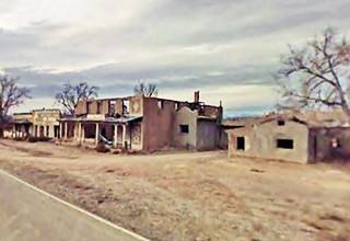 Ruins of the Trading Post, Domingo NM burned ruins of a trading post, leafless trees and highway runs in front