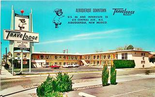 1960s postcard TraveLodge ABQ Motel postcard 1960s, cars, black neon sign, L-shaped layout, on a corner