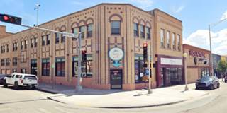 color. 2 story brick building on a city corner, cars, traffic light