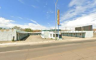 U-layout, central office, neon sign next to it, single story, flat roof vacant motel US 66 in front