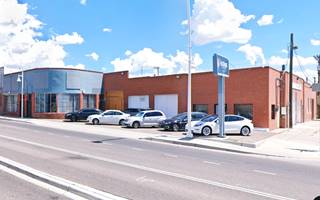 on the left glazed store with curved wall, brick building with service bays and cars parked