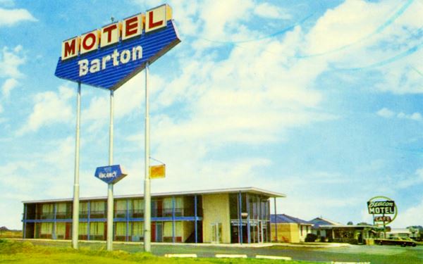 1970s postcard two motels with neon signs and cars