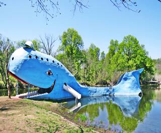 Blue concrete whale in pond