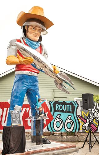 Buck Atom, a modern Muffler Man in Tulsa Oklahoma Muffler Man, belt buckle reads 66, cowboy hat atop an acrylic space helmet, holds a rocket in his hands