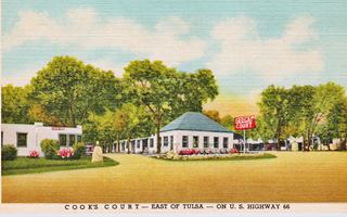 color linnen 1940s postcard, hip roof office left, red and white neon sign reads COOKS COURT US 66 runs in front