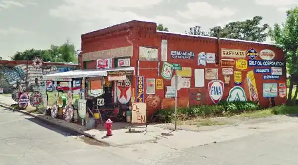 old red brick building covered with vintage enamel signs