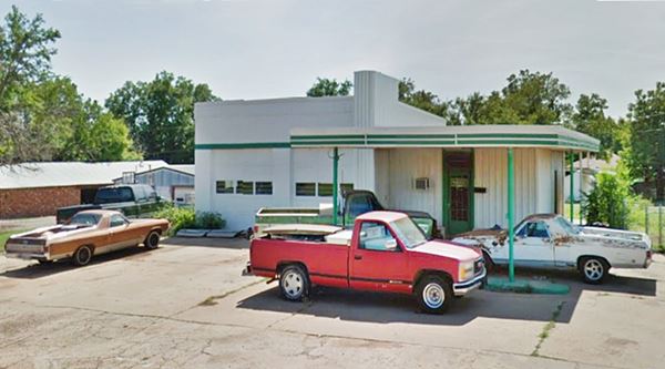 1950s gas station with old cars parked