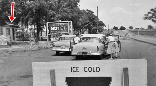 black and white photo of US66 and the motel, people and a parked car