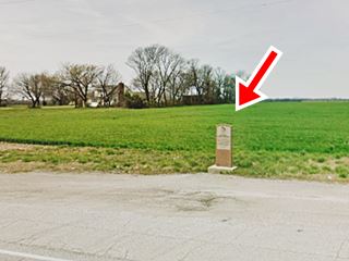 granite marker by shoulder, field behind it
