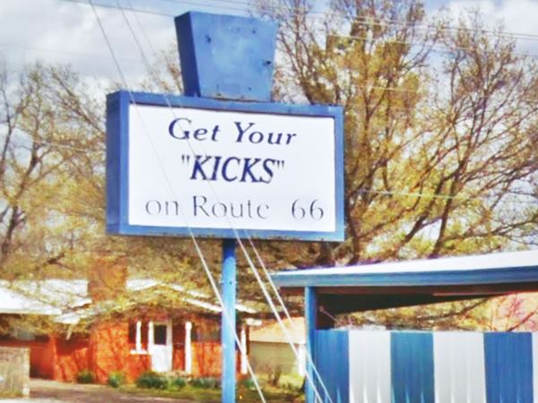 blue sign with letters on white background spelling "Get Your Kicks on Route 66"