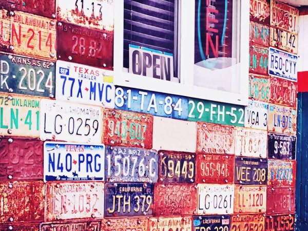 scores of old licence plates attached to a wall