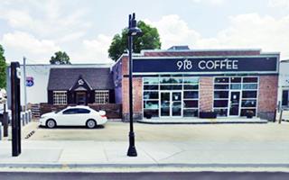 Cottage style gas station single story left by US 66 shield on wall, 2 former service bays right, a Coffee shop