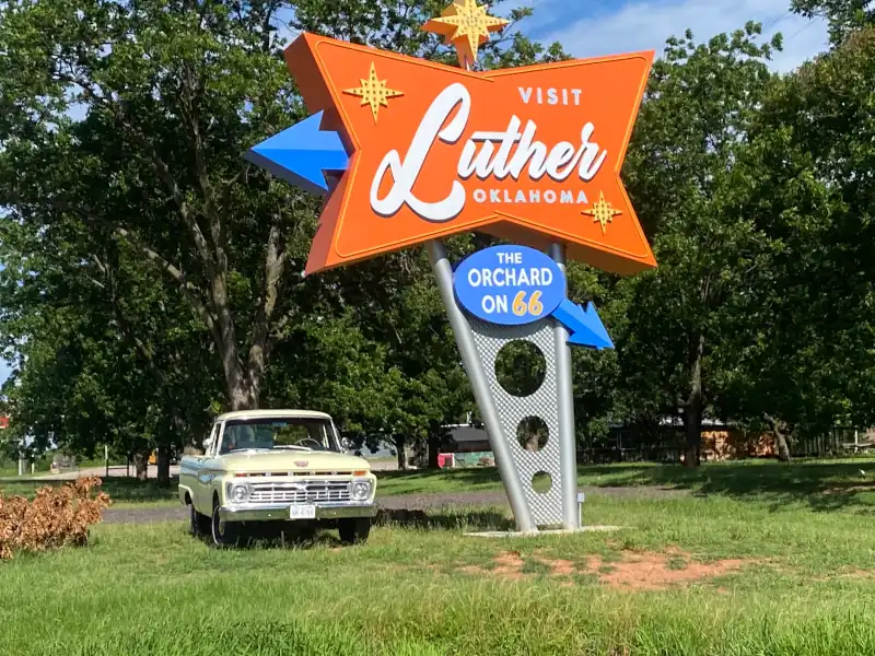 orange, blue googie style sign, with arrows, stars and white letters