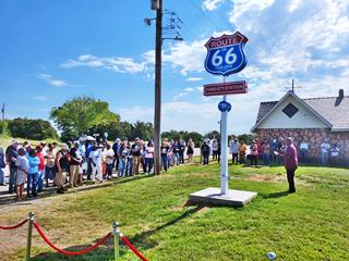 Dedication Monument at Threatt Route 66 Luther people by a Route 66 blue, red, white shield