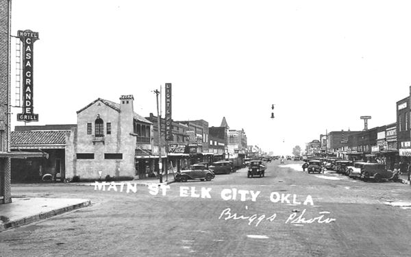 black and white 1930s photo with cars, buildings and Route 66 intersection with Main St. Elk City